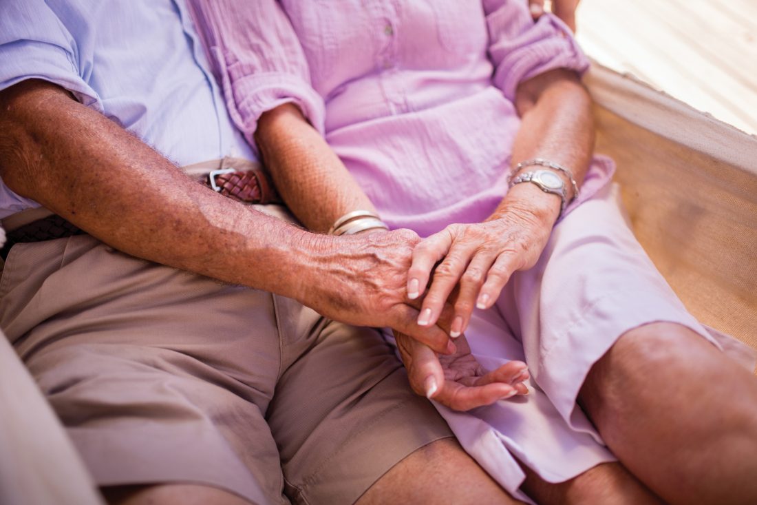 Cropped shot of a senior couple sitting close together and holding hands lovingly